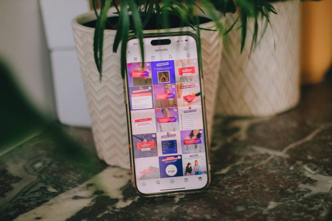 a cell phone sitting on top of a table next to a potted plant a cell phone sitting on top of a table next to a potted plant