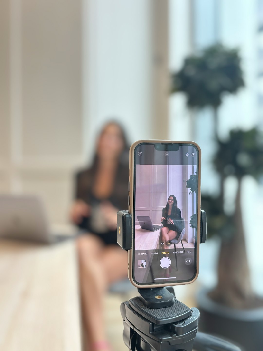 Woman recording herself on smartphone in office. Woman recording herself on smartphone in office.